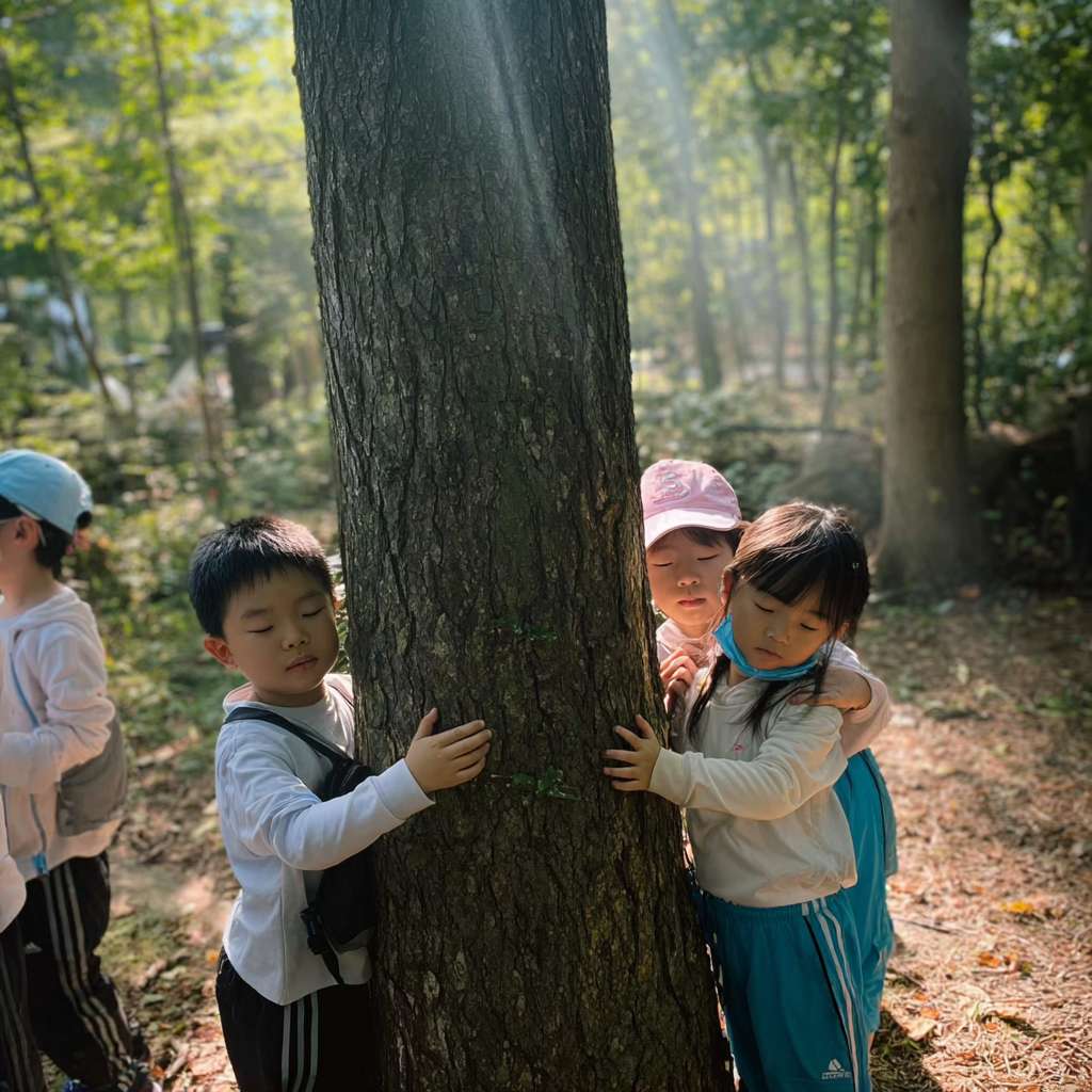 https://img-xpc-mj0.xpccdn.com/prod/upload/53afdc64-cd2c-4959-a03d-1d4265145417/%E5%BE%AE%E4%BF%A1%E5%9B%BE%E7%89%87_20251111164933_1442_207.png~tplv-5yakomv5zn-auto-v1%3A1024%3A0%3Aq75.jpg 三位大約十至十一歲的小學生圍繞著一棵大樹，雙手輕觸樹幹，閉上眼睛感受大自然的氣息。陽光穿過樹葉灑下，光線柔和自然，背景是森林或公園環境，氣氛平靜、溫暖、真實。真實攝影風格，運動服整潔，構圖自然 --ar 1:1 --v 7 --stylize 100 --fast --iw 1 --no 水印