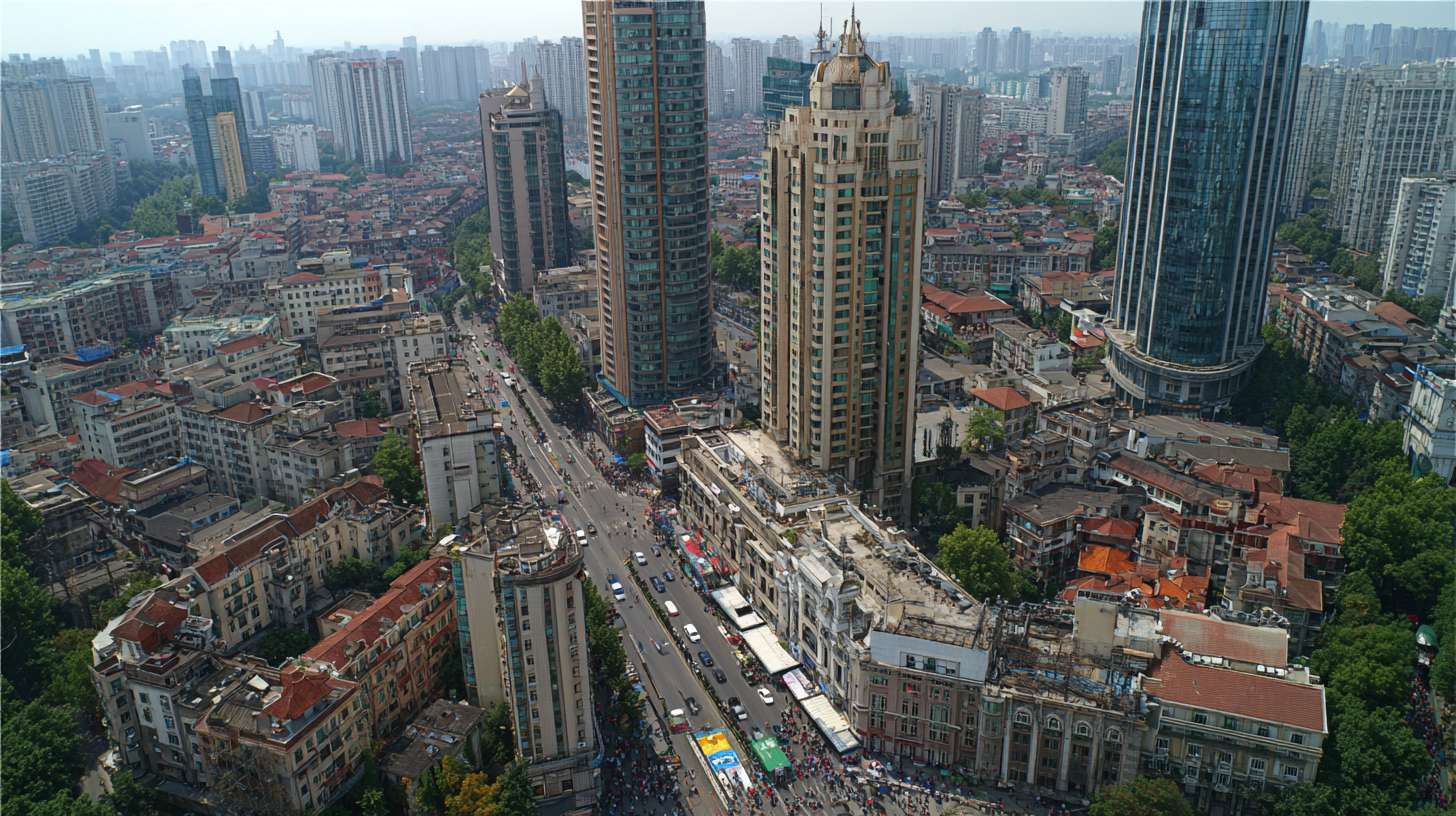 武汉城市全景，高楼与老建筑并存，车流穿梭，人群活动 --ar 16:9 --v 7 --stylize 100 --fast --no 水印