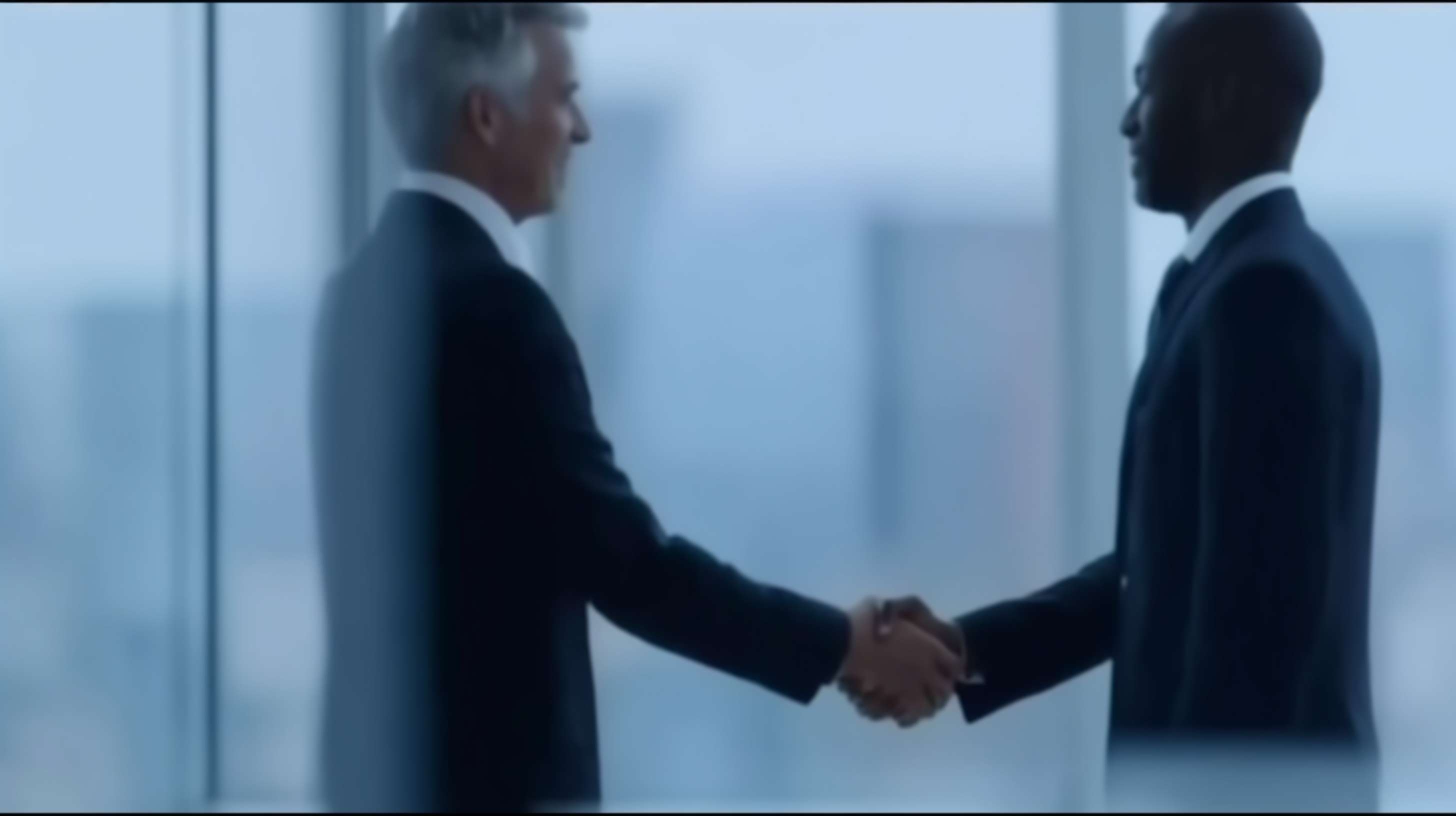 两个中年男人，亚洲人种，深色皮肤，短发，穿着深色西装，正在一个现代办公室环境中握手，背景是大面积的玻璃窗，透过玻璃可以看到外面的城市景观，光线明亮，整体氛围正式而专业。男人们在画面的中心位置，握手的手部占据画面的大部分，背景的玻璃窗和城市景观模糊处理，突出前景的握手动作。画面风格为照片现实主义，整体色调偏冷，突显专业和正式的场合。 --ar 16:9 --v 7 --stylize 100 --fast --sref https://img-xpc-mj0.xpccdn.com/prod/upload/34fe3e9c-221a-4842-b265-184af228609c/09f5db4c04c225adf9fea1c6bf839cad.png~tplv-5yakomv5zn-auto-v1%3A1024%3A0%3Aq75.jpg --no 水印
