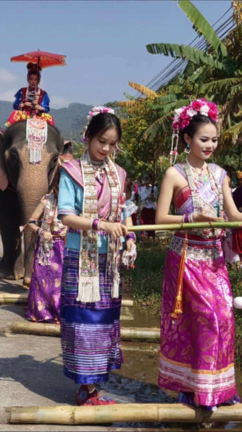 https://img-xpc-mj0.xpccdn.com/prod/upload/2cc4bcd7-778c-45f0-b39e-ccb20a641317/ScreenShot_2025-12-03_125545_442.png~tplv-5yakomv5zn-auto-v1%3A1024%3A0%3Aq75.jpg 夏天西双版纳傣族少女成群结队在街上穿着民族傣家服饰，旁边有人骑着大象 --ar 9:16 --v 7 --stylize 100 --fast --iw 1 --no 水印