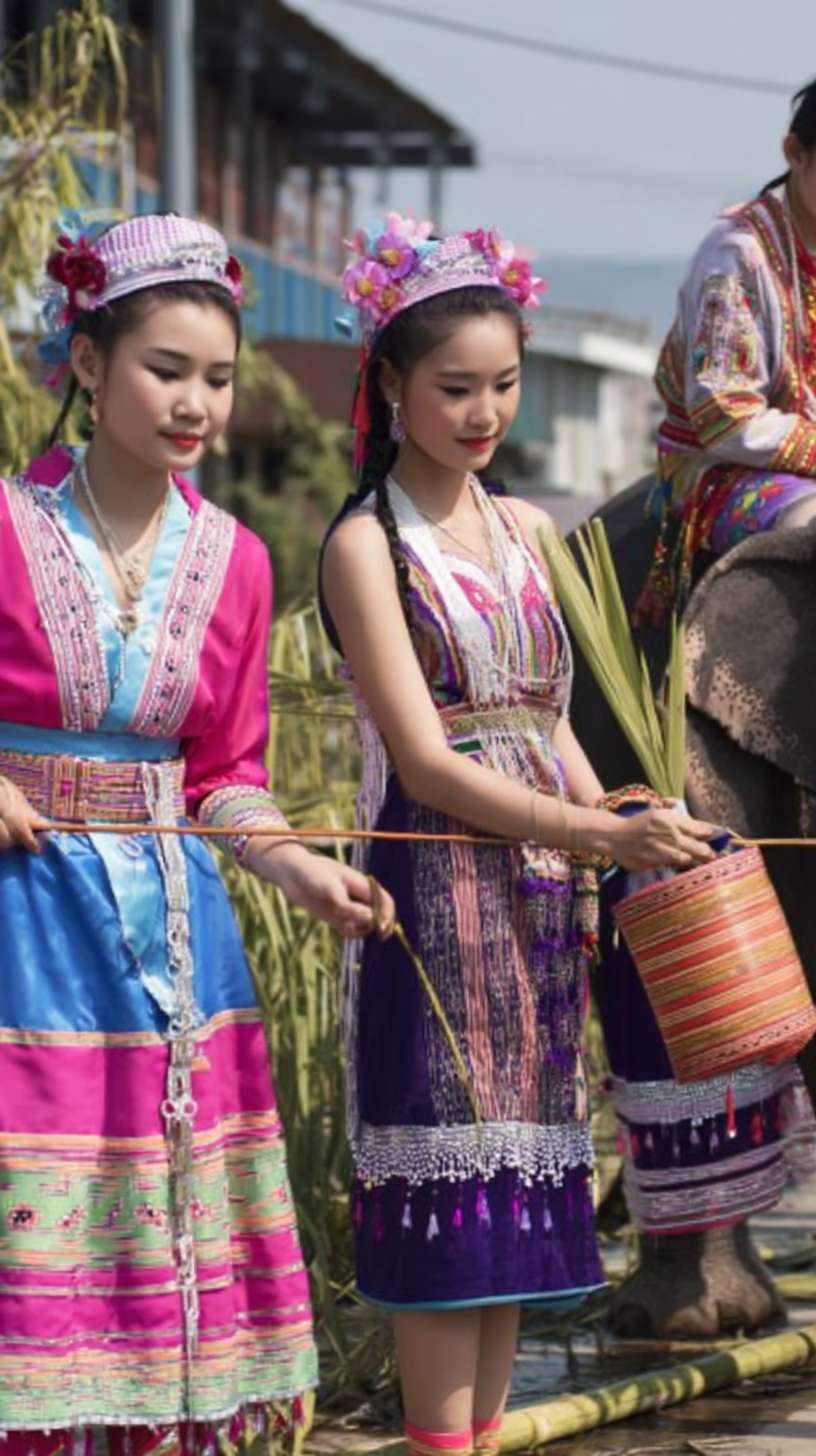 https://img-xpc-mj0.xpccdn.com/prod/upload/2cc4bcd7-778c-45f0-b39e-ccb20a641317/ScreenShot_2025-12-03_125545_442.png~tplv-5yakomv5zn-auto-v1%3A1024%3A0%3Aq75.jpg 夏天西双版纳傣族少女成群结队在街上穿着民族傣家服饰，旁边有人骑着大象 --ar 9:16 --v 7 --stylize 100 --fast --iw 1 --no 水印