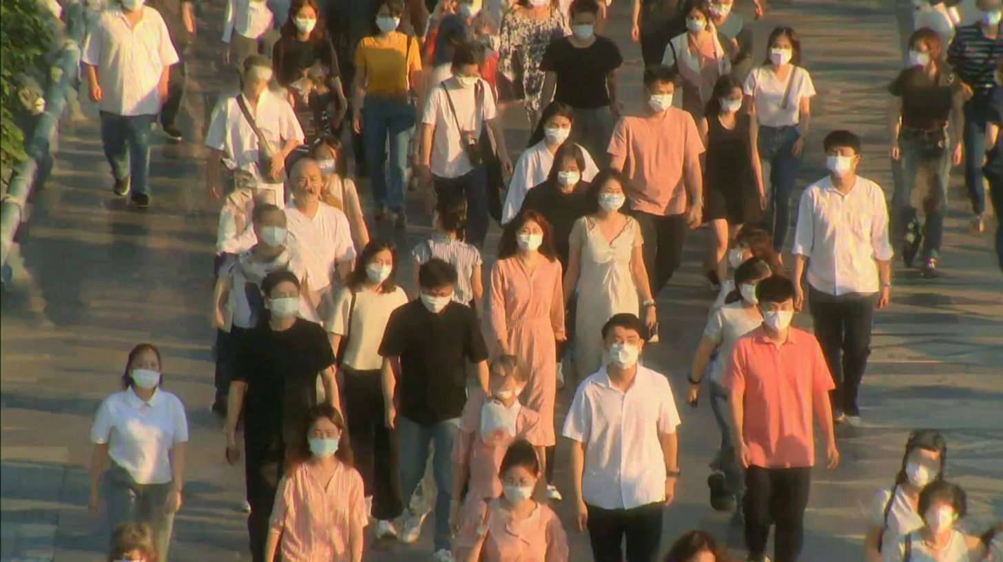 一群不同年龄段的人，包括亚洲人和白人，穿着各种颜色的衣服，如白色、粉色、黄色和黑色，大多数人戴着口罩，正在一个阳光明媚的日子里穿过一个宽敞的人行道。人行道上有明显的阴影，表明阳光从左侧照射。人们的姿势各异，有的正面朝向镜头，有的侧面或背面。画面风格为现实主义，整体氛围明亮而活跃。 --ar 16:9 --v 7 --stylize 100 --fast --sref https://img-xpc-mj0.xpccdn.com/prod/upload/a5ba7765-3f47-4272-9c97-a0abb955ceb6/%E6%88%AA%E5%B1%8F2025-08-01%2003.40.03.png~tplv-5yakomv5zn-auto-v1%3A1024%3A0%3Aq75.jpg --sw 310 --no 水印